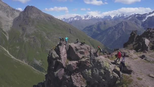 Vista aérea de viajantes no topo da montanha com as encostas cobertas por grama verde. Clipe. Voando sobre colinas e montagens de tirar o fôlego, beleza da natureza. — Vídeo de Stock