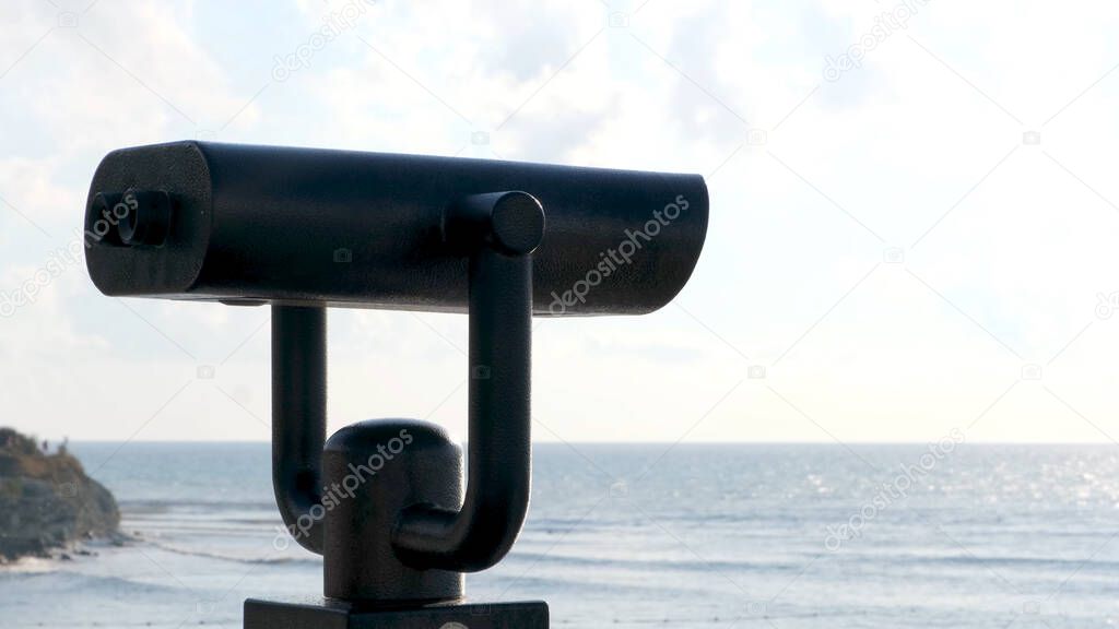 Public beach binoculars, operated with coins with the ocean in the background. Concept. Touristic binoculars, optical instrument for breathtaking views.
