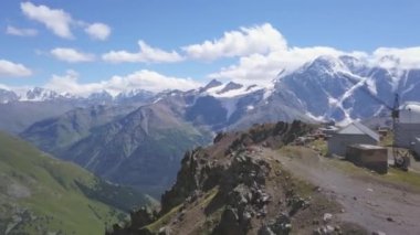 Yeşil çimlerle kaplı yamaçlarla dağın tepesindeki gezginlerin hava manzarası. Şarjör. Tepelerin üzerinde uçmak ve nefes kesici atlar, doğanın güzelliği..