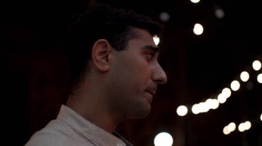 Beyaz gömlekli bir adam akşam yemeğinde güzel bir kız arkadaşla konuşuyor. Medya. Genç ve güzel bir çift gecenin geç saatlerinde açık terasta oturmuş içkilerini yudumluyor..