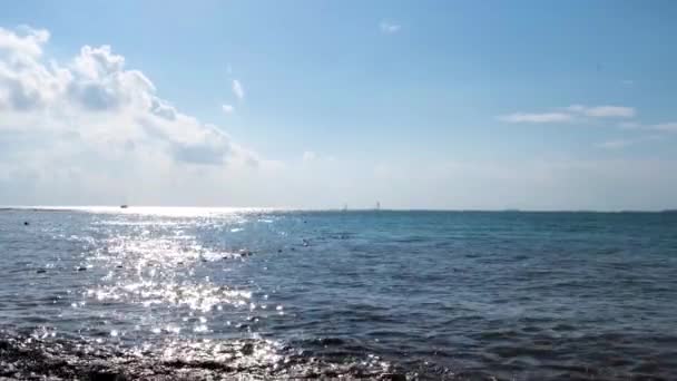 Zomer natuurlijk landschap met rimpelende zee oppervlak schijnt helder op blauwe bewolkte hemel achtergrond. Concept. Zon weerspiegeld in wateroppervlak op een zomerzonnige dag. — Stockvideo