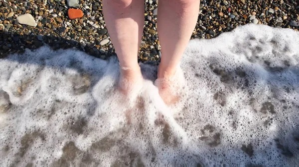 Top close up άποψη της γυναίκας όμορφα πόδια σε ένα θαλασσινό νερό και πέτρες φόντο. Έννοια. Έννοια του τουρισμού, τα ταξίδια, τις διακοπές, το κορίτσι χαλαρώνοντας σε ζεστά νερά της θάλασσας. — Φωτογραφία Αρχείου