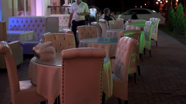 남부 도시의 온화 한 저녁에 옥외 테라스가 텅 비어 있다. 미디어. 야외 카페나 식당에 마련 된 아름다운 탁자 위에는 테이크 웨이 음식이 차려져 있다. — 비디오