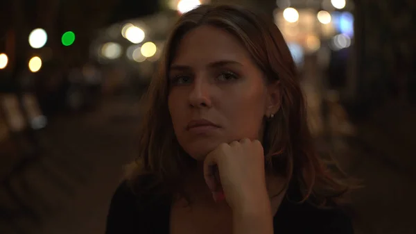 Schöne Frauenporträt in der Stadt bei Nacht auf verschwommenem Hintergrund von Outdoor-Restaurant und leuchtenden Lichtern. Medien. Sensible sexy Mädchen Blick in die Kamera im Freien. — Stockfoto