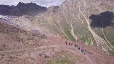 Dağ yamacına tırmanan yürüyüş ekibinin hava görüntüsü. Şarjör. Seyahat ve spor yaşam tarzı konsepti, bir grup turist dağ zirvesine doğru yürüyor.