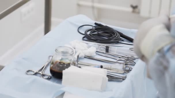 Close up of sterile surgical tools for laparoscopic surgery. Action. Tools for medical surgery with the glass bowl of iodine, concept of health and medicine. — Stock Video