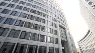 Şehir işindeki bir diktatörün düşük açılı görüntüsü. Başla. Birçok penceresi ve beyaz cepheli, mimari konsepti olan güzel, modern bir ofis binası olan bir sokak..