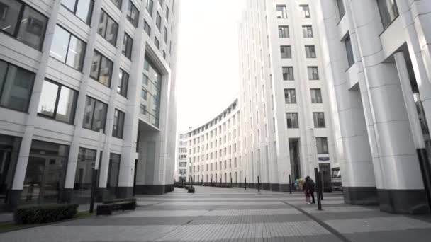 都市ビジネス地区の低角度ビュー。行動だ。多くの窓と白いファサード、建築の概念を持つ美しい近代的なオフィスビルのある通り. — ストック動画