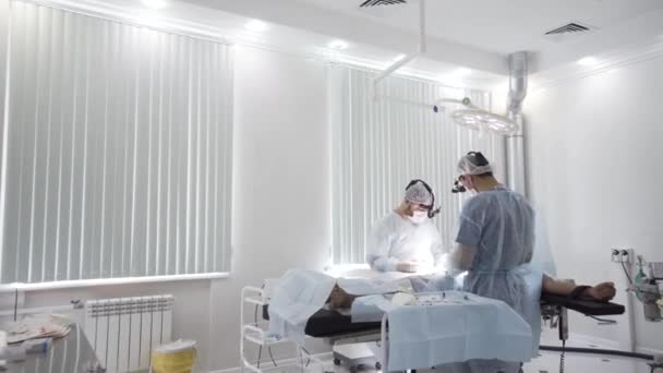 Proses operasi di ruang operasi steril. Mulai. Dua dokter profesional melakukan operasi nyata dengan semua peralatan yang dibutuhkan, latar belakang medis dengan efek penyimpangan waktu. — Stok Video