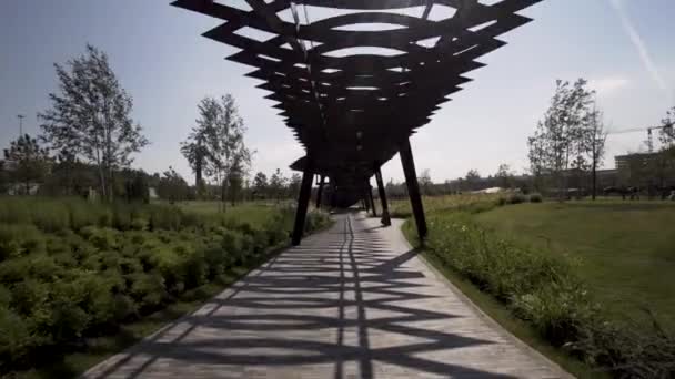 티우 펠 베 바 로슈 차 공원의 특이 한 목조 건축물 아래를 걷고 있다. 행동. 러시아의 모스크바에 있는 현대 공공 장소인 투 펠 숲 공원. — 비디오