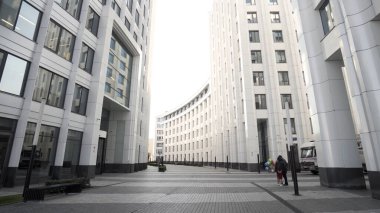 Şehir işindeki bir diktatörün düşük açılı görüntüsü. Başla. Birçok penceresi ve beyaz cepheli, mimari konsepti olan güzel, modern bir ofis binası olan bir sokak..
