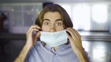 Koronavirüs karantinası sırasında mavi bir maske takan sakallı beyaz bir adamın fotoğrafını çek. Medya. Coronavirus, COVID-19 salgını, sağlık konsepti.