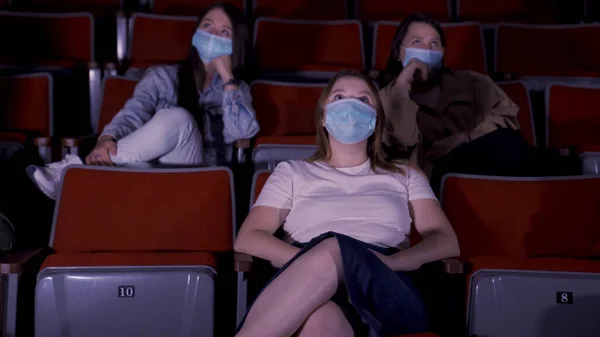 Bio, underhållning, pandemi och socialt distanskoncept. Media. Personer som bär ansiktsskydd medicinska masker för att förebygga virussjukdomar titta på film på teater. — Stockfoto