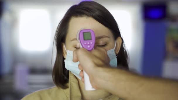 Close up of operator checks fever by digital thermometer for scanning and protection from coronavirus COVID-19. Mídia. Homem tentando medir a temperatura corporal com termômetro na testa de um — Vídeo de Stock