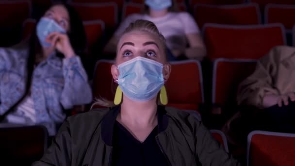 Les gens au cinéma avec masque de protection gardent leurs distances pour éviter tout contact physique. Les médias. Coronavirus COVID-19 protection de la maladie, pratique de distanciation sociale, la femme se sent excitée et choquée. — Video