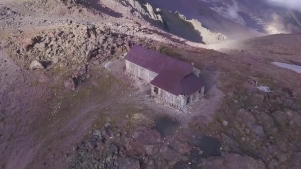 Vue aérienne des ruines de la maison en brique près du versant de la montagne rocheuse. Clip. Ancien bâtiment mystérieux abandonné sur situé au sommet d'une grande colline. — Video