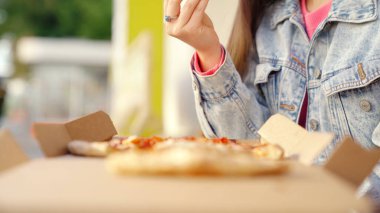 Lezzetli pizza dilimleri alan genç kadınların ellerine yakın çekim. Medya. Bir dilimden diğerine hareket etmek, yazları dışarıda öğle yemeği yemek..