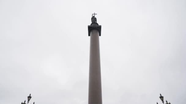 La Columna Alexander en medio de la plaza del Palacio en San Petersburgo, Rusia. Acción. Vista inferior de una columna de granito gigante sobre el fondo nublado del cielo. — Vídeos de Stock