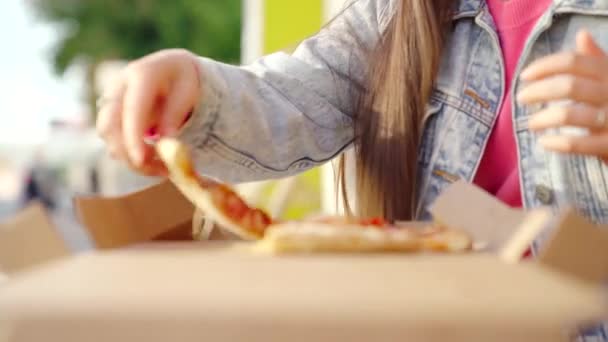 Comida italiana almuerzo, mujer comiendo pizza con mozzarella al aire libre. Medios. Primer plano de la mano femenina joven tomando una rebanada de pizza en un día soleado de verano. — Vídeo de stock