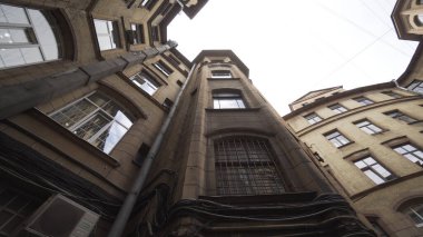 Parlak gökyüzü arka planında antik yüksek avlu. Başla. St. Petersburg 'un tipik mimarisi, eski güzel yuvarlak evlerin alt manzarası..