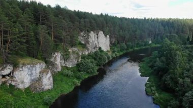 Beyaz uçurumlar ve sık bir orman ile pitoresk bir arazide akan bir nehrin nefes kesici hava görüntüsü.