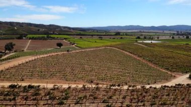 Uçsuz bucaksız ve tepe tepe bir arazide toprak yolda giden bir kamyonetin hava görüntüsü. Medya