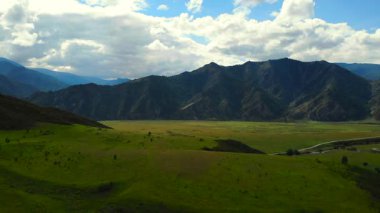 Güneşli bir yaz gününde engin yeşil bir dağ vadisinde hareket eden bulutların gölgeleri. Medya