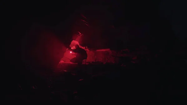 Silhouette Eines Mannes Der In Volliger Dunkelheit Eine Hohle Mit Einem Rot Brennenden Signalfeuer Erkundet Archivmaterial Mannlicher Palaontologe Hockt Und Schaut In Den Schmalen Gang Eintritt Tief Stock Photo 314420504