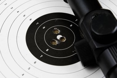 Ateş ve pnömatik silah. Tahta bir masada kurşun mermi ile kalkan ve hits. Karanlık arka plan.