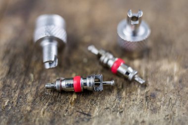 İç lastik valf bir ahşap Atölyesi tablo. İç lastikler ve araba lastik tamiri için icin için aksesuarlar. Koyu arka plan.