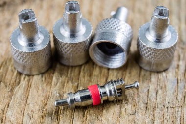 İç lastik valf bir ahşap Atölyesi tablo. İç lastikler ve araba lastik tamiri için icin için aksesuarlar. Koyu arka plan.