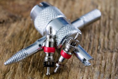 İç lastik valf bir ahşap Atölyesi tablo. İç lastikler ve araba lastik tamiri için icin için aksesuarlar. Koyu arka plan.