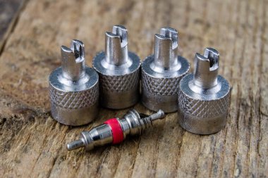 İç lastik valf bir ahşap Atölyesi tablo. İç lastikler ve araba lastik tamiri için icin için aksesuarlar. Koyu arka plan.