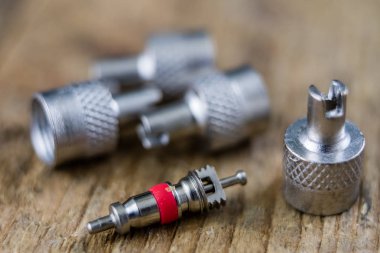 İç lastik valf bir ahşap Atölyesi tablo. İç lastikler ve araba lastik tamiri için icin için aksesuarlar. Koyu arka plan.