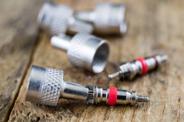 İç lastik valf bir ahşap Atölyesi tablo. İç lastikler ve araba lastik tamiri için icin için aksesuarlar. Koyu arka plan.