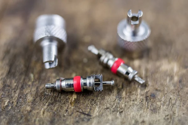 İç lastik valf bir ahşap Atölyesi tablo. İç lastikler ve araba lastik tamiri için icin için aksesuarlar. Koyu arka plan.