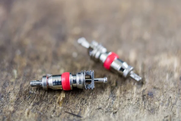 İç lastik valf bir ahşap Atölyesi tablo. İç lastikler ve araba lastik tamiri için icin için aksesuarlar. Koyu arka plan.