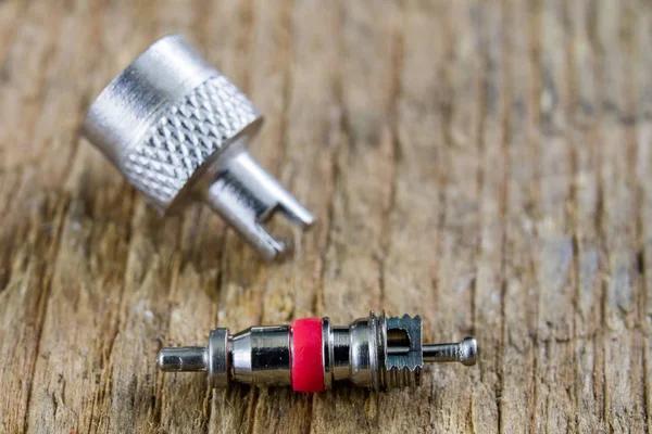 İç lastik valf bir ahşap Atölyesi tablo. İç lastikler ve araba lastik tamiri için icin için aksesuarlar. Koyu arka plan.