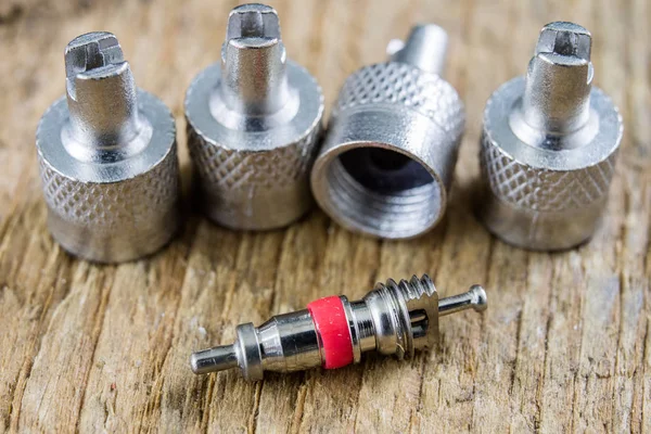 İç lastik valf bir ahşap Atölyesi tablo. İç lastikler ve araba lastik tamiri için icin için aksesuarlar. Koyu arka plan.