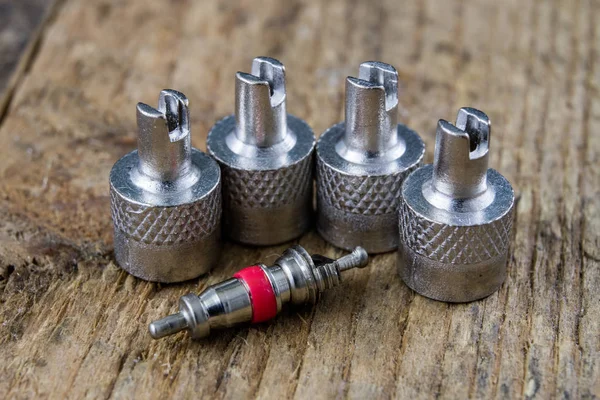 İç lastik valf bir ahşap Atölyesi tablo. İç lastikler ve araba lastik tamiri için icin için aksesuarlar. Koyu arka plan.