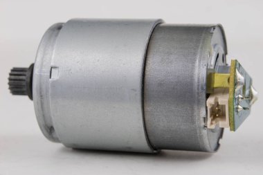 Bir beyaz atölye tabloda küçük elektrik motoru. Küçük elektrikli cihazlarda kullanılan elektrikli sürücü. Açık renkli.