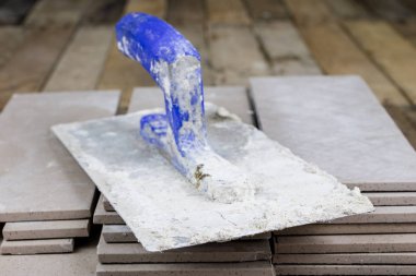 Fayans yere yerleştirmeye ilişkin. Aksesuarları ve malzemeleri Ahşap Atölyesi masanın üzerine düzenlenmiş bir inşaat işçisi. Koyu arka plan