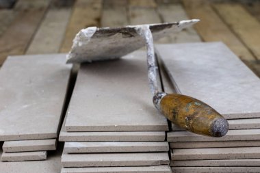 Fayans yere yerleştirmeye ilişkin. Aksesuarları ve malzemeleri Ahşap Atölyesi masanın üzerine düzenlenmiş bir inşaat işçisi. Koyu arka plan