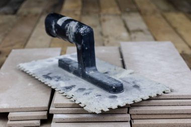 Fayans yere yerleştirmeye ilişkin. Aksesuarları ve malzemeleri Ahşap Atölyesi masanın üzerine düzenlenmiş bir inşaat işçisi. Koyu arka plan