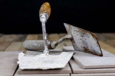 Fayans yere yerleştirmeye ilişkin. Aksesuarları ve malzemeleri Ahşap Atölyesi masanın üzerine düzenlenmiş bir inşaat işçisi. Koyu arka plan