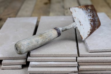 Fayans yere yerleştirmeye ilişkin. Aksesuarları ve malzemeleri Ahşap Atölyesi masanın üzerine düzenlenmiş bir inşaat işçisi. Koyu arka plan