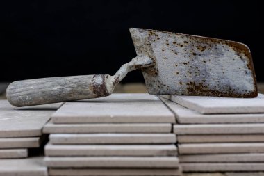 Fayans yere yerleştirmeye ilişkin. Aksesuarları ve malzemeleri Ahşap Atölyesi masanın üzerine düzenlenmiş bir inşaat işçisi. Koyu arka plan