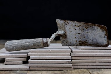 Fayans yere yerleştirmeye ilişkin. Aksesuarları ve malzemeleri Ahşap Atölyesi masanın üzerine düzenlenmiş bir inşaat işçisi. Koyu arka plan