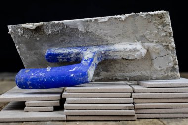 Fayans yere yerleştirmeye ilişkin. Aksesuarları ve malzemeleri Ahşap Atölyesi masanın üzerine düzenlenmiş bir inşaat işçisi. Koyu arka plan