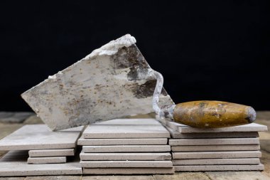 Fayans yere yerleştirmeye ilişkin. Aksesuarları ve malzemeleri Ahşap Atölyesi masanın üzerine düzenlenmiş bir inşaat işçisi. Koyu arka plan